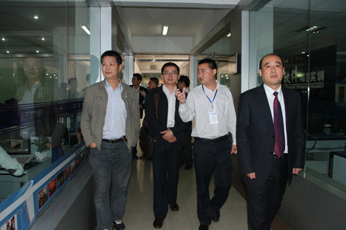 四川新华电脑学院校长助理王强向马处长等领导介绍实训室