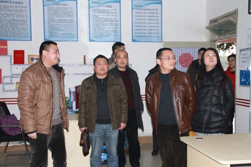 四川新华电脑学院校长助理王强向刘局长介绍教师办公室文化