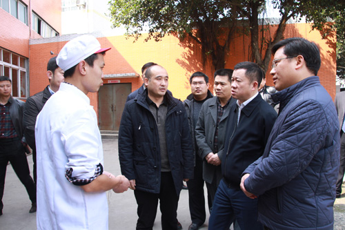 周先毅县长向学校食堂管理员了解情况