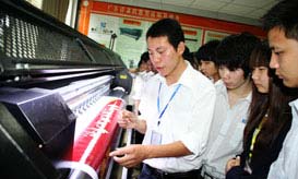 教师正在为学子讲解喷绘机操作要领